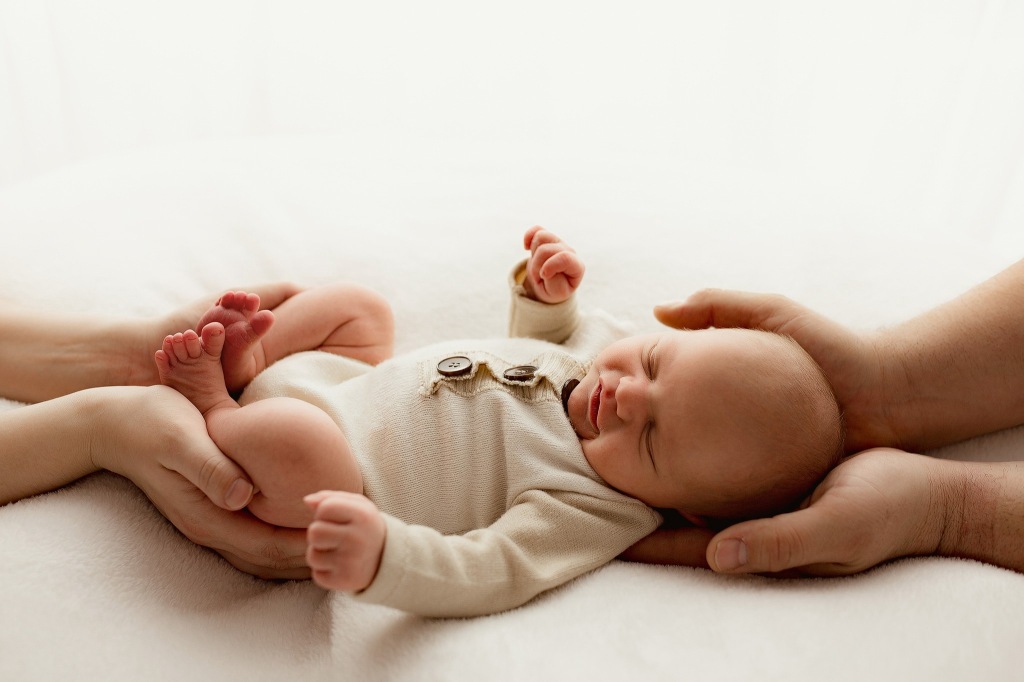 newborn photo with parents hands 