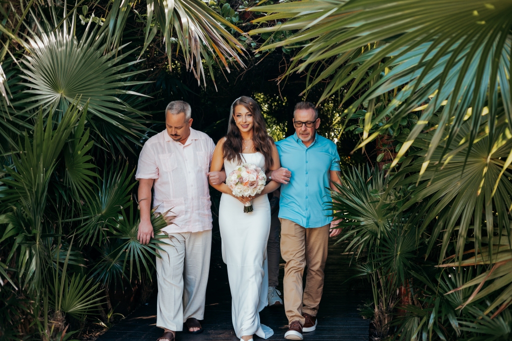 bride with dad and step dad walking her down the aisle at destination wedding in Mexico