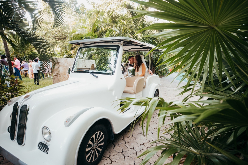 bride and groom in a vintage golf cart 