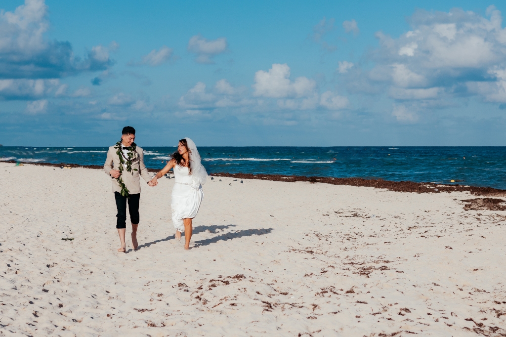 playa del carmen wedding photo of bride and groom running on the beach