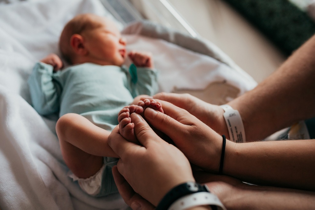 Parents holding baby feet in the hospital